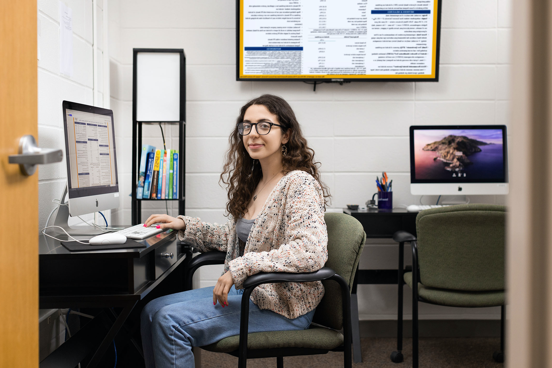 Veronica Bucci sits at a desk.